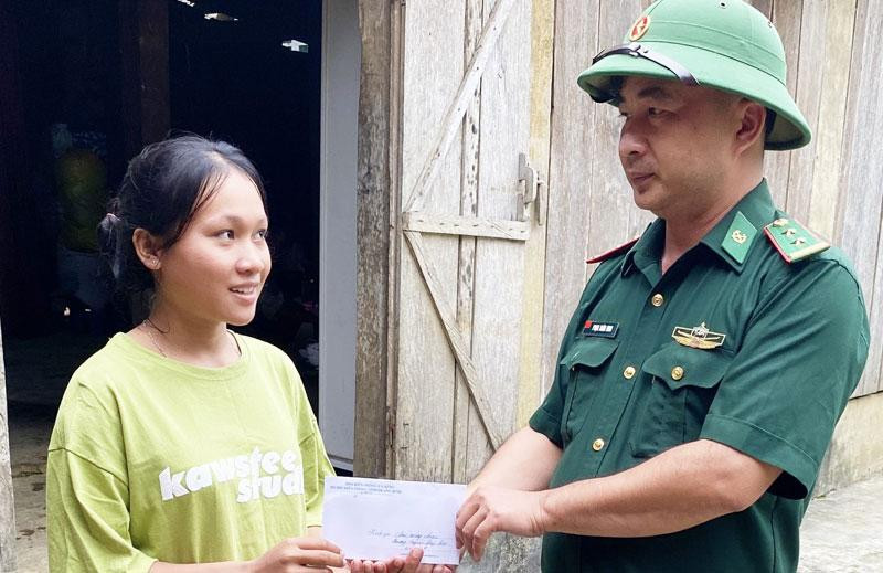 Trung tá Phạm Xuân Ninh, Chính trị viên phó Đồn Biên phòng Cà Xèng động viên, tặng quà cho Cao Thị Hằng trước ngày nhập học tại Huế.