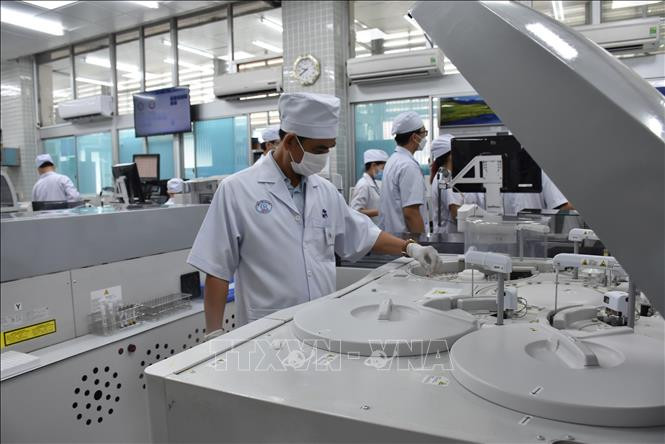 Nhân viên y tế Bệnh viện Chợ Rẫy vận hành hệ thống máy xét nghiệm.