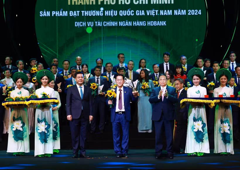 Tổng Giám đốc HDBank Phạm Quốc Thanh nhận biểu trưng Thương hiệu Quốc gia Việt Nam 2024 từ Thủ tướng Chính phủ Phạm Minh Chính và hoa chúc mừng từ Bộ trưởng Công thương Nguyễn Hồng Diên với những đóng góp của HDBank cho thị trường tài chính và sự phát triển kinh tế Việt Nam.