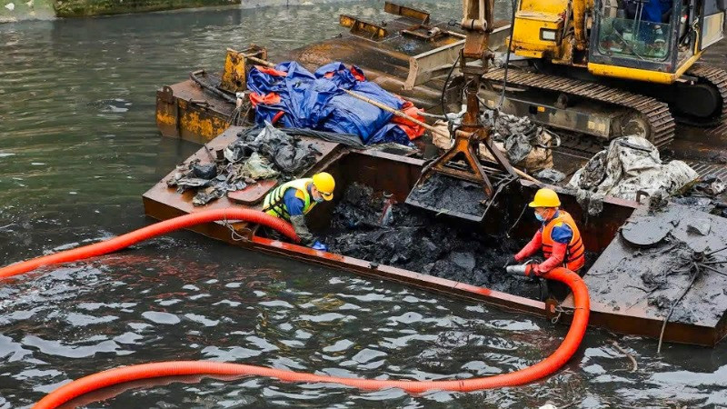 Công nhân Công ty Thoát nước Hà Nội tiến hành nạo vét bùn, cải tạo môi trường nước sông Tô Lịch. Ảnh: Tuấn Sơn