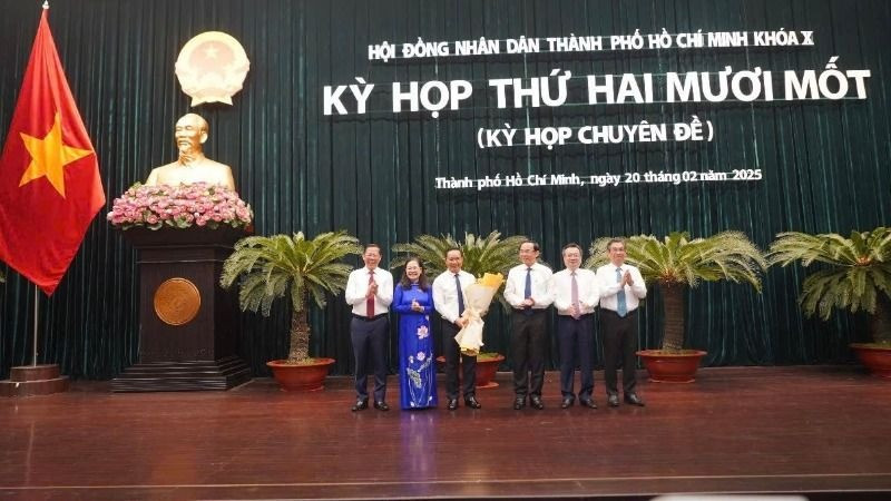 Đồng chí Nguyễn Văn Được nhận hoa chúc mừng của các đồng chí lãnh đạo Thành phố Hồ Chí Minh. (Ảnh: Thế Anh)