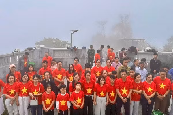 Du khách và nhân dân xã Sín Thầu thực hiện nghi lễ chào cờ dưới chân Cột cờ A Pa Chải trong Ngày Quốc tế Lao động 1/5.