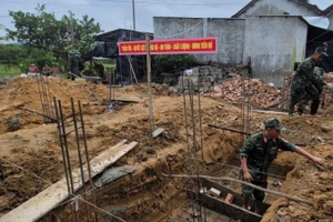 Lực lượng Quân khu 5 chạy đua với thời gian, không kể nắng mưa hay ngày đêm, để sớm hoàn thành nhà mới cho người dân vùng lũ. (Ảnh: ĐÌNH TĂNG)