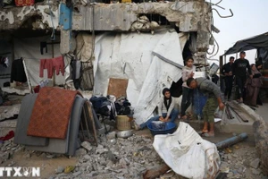 Người dân Palestine sinh sống giữa đống đổ nát trong những ngôi nhà bị phá hủy do xung đột ở Jabalia, Dải Gaza. (Ảnh: THX/TTXVN)