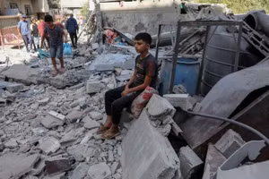 Một cậu bé Palestine ngồi giữa đống đổ nát sau cuộc không kích của Israel nhằm vào khu vực Al-Zawaida, trung tâm Dải Gaza, ngày 25/9/2025. (Ảnh: TÂN HOA XÃ)