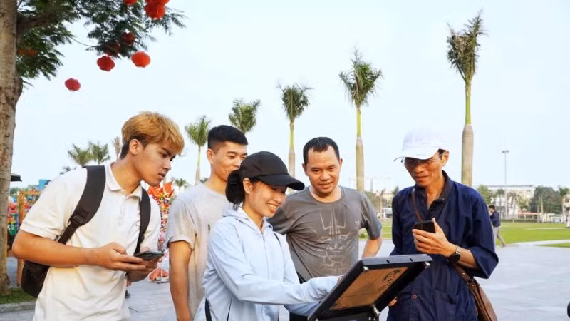 Nhiều du khách hào hứng thử nghiệm check-in với bảng gắn chip NFC tại Quảng trường Hồ Chí Minh.