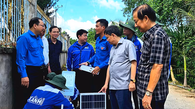 Các chiến sĩ tình nguyện thực hiện lắp trụ đèn chiếu sáng của công trình “Thắp sáng đường quê”.