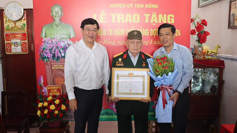 Bí thư Tỉnh ủy Đồng Tháp Lê Quốc Phong trao Huy hiệu Đảng cho đồng chí Hồ Văn Ba; Bí thư Huyện ủy Tân Hồng Nguyễn Minh Ngọc tặng hoa chúc mừng.