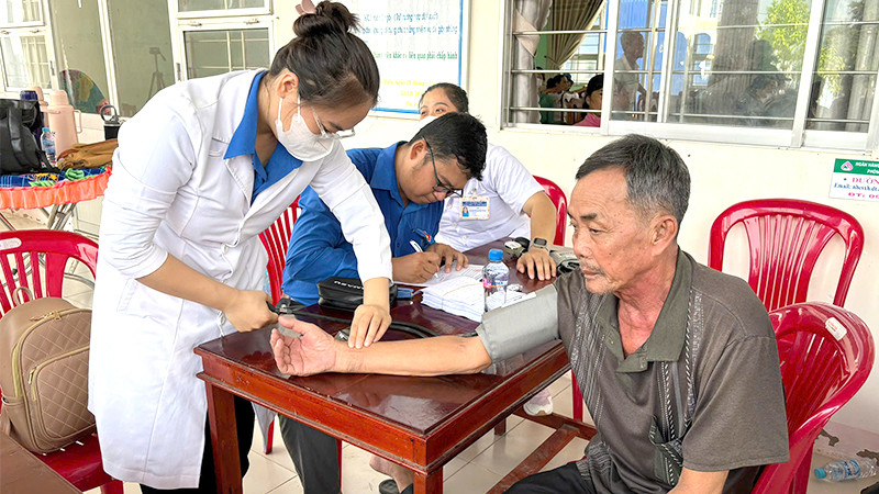 Các y, bác sĩ tình nguyện khám bệnh miễn phí cho người dân xã Phú Điền, huyện Tháp Mười.
