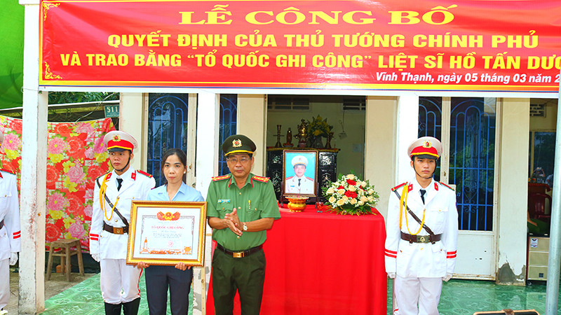 Đại tá Nguyễn Văn Hiểu, Giám đốc Công an tỉnh Đồng Tháp trao Bằng “Tổ quốc ghi công” cho vợ Liệt sĩ Hồ Tấn Dương.