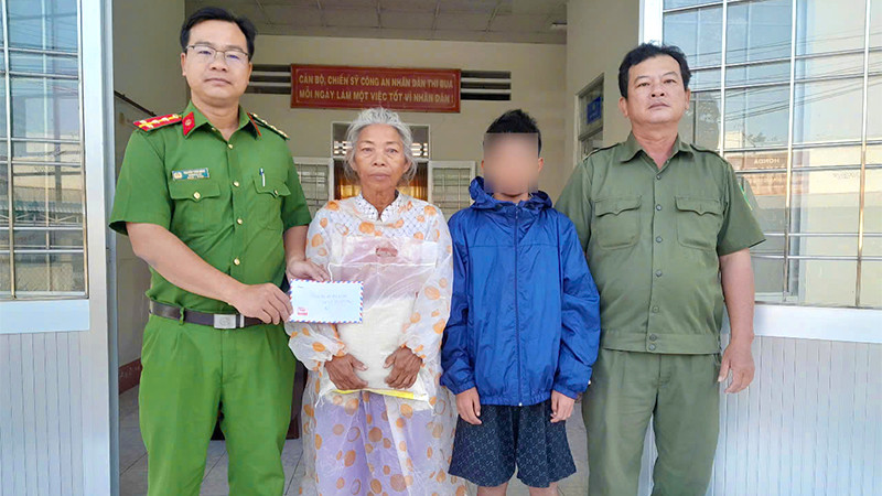 Công an xã An Bình hỗ trợ cháu bé đi lạc. (Ảnh: Công an cung cấp)