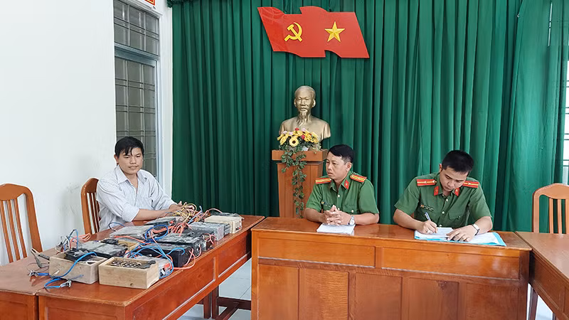 Anh Ngô Vũ Minh Dương giao nộp 18 công cụ kích điện dùng để đánh bắt thủy sản. (Ảnh: Công an cung cấp)