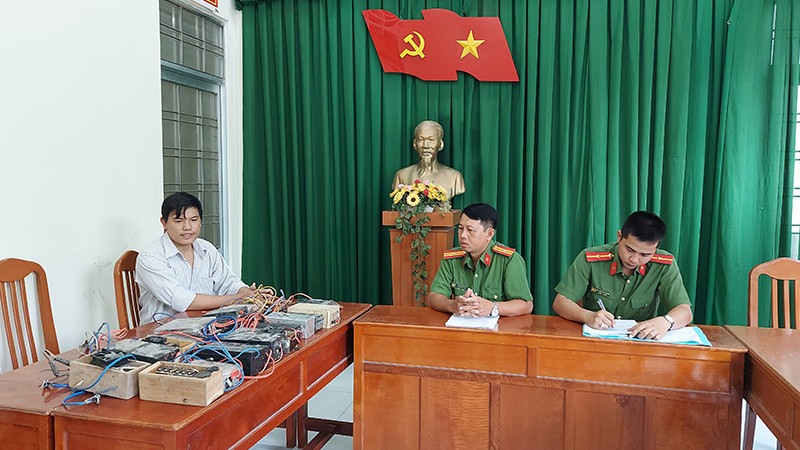Anh Ngô Vũ Minh Dương giao nộp 18 công cụ kích điện dùng để đánh bắt thủy sản. (Ảnh: Công an cung cấp)