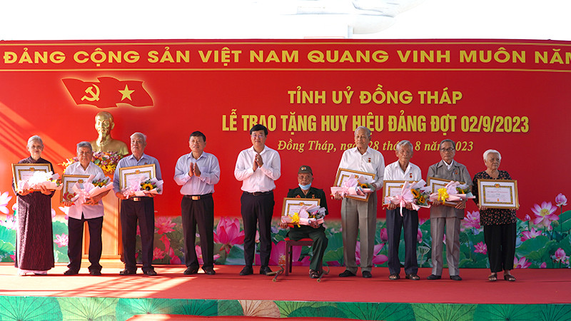 Bí thư Tỉnh ủy Đồng Tháp Lê Quốc Phong trao Huy hiệu Đảng cho các đảng viên. (Ảnh: HỮU NGHĨA)