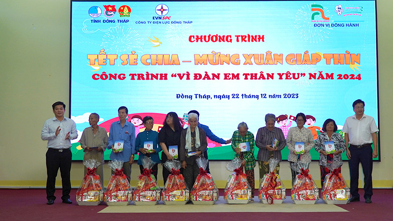 Chủ tịch Ủy ban nhân dân huyện Tháp Mười Đoàn Thanh Bình và Phó Giám đốc Công ty Điện lực Đồng Tháp Nguyễn Chí Thanh trao tặng quà. (Ảnh: HỮU NGHĨA)