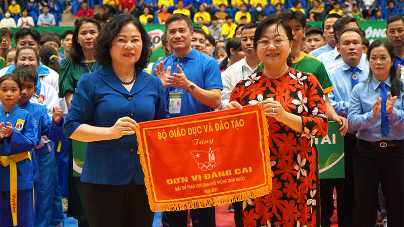 Thứ trưởng Giáo dục và Đào tạo Ngô Thị Minh trao cờ lưu niệm cho Giám đốc Sở Giáo dục và Đào tạo Nguyễn Thúy Hà, đại diện địa phương đăng cai