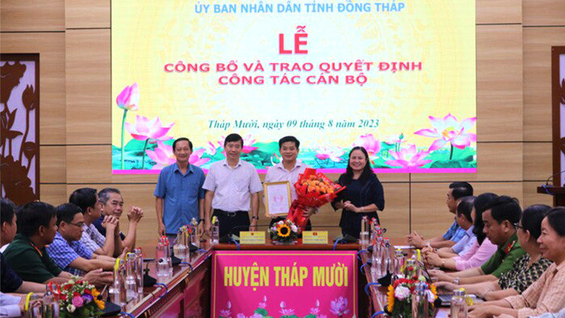 Ông Phạm Thiện Nghĩa trao quyết định, Bí thư Huyện ủy Tháp Mười Trần Thị Quý tặng hoa chúc mừng ông Đoàn Thanh Bình. (Ảnh: THÀNH NHƠN)