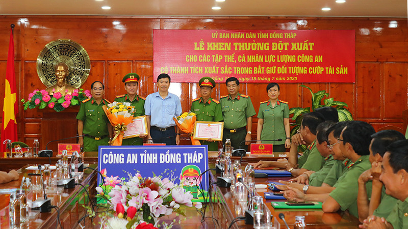 Chủ tịch Ủy ban nhân dân tỉnh Đồng Tháp Phạm Thiện Nghĩa cùng Ban Giám đốc Công an tỉnh Đồng Tháp trao bằng khen và hoa chúc mừng các tập thể có thành tích xuất sắc. (Ảnh: PHƯỚC THANH)