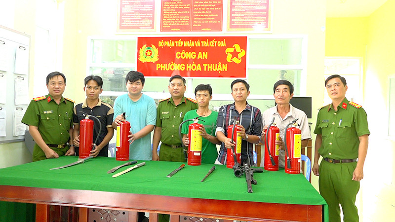 Người dân giao nộp vũ khí tại Công an phường Hòa Thuận và nhận bình chữa cháy. (Ảnh: Công an cung cấp)