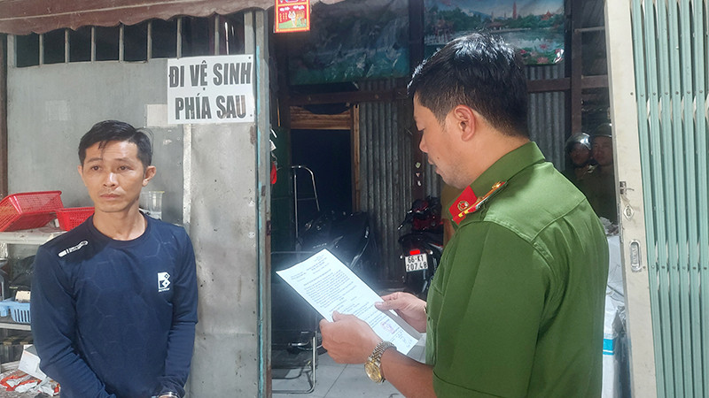 Nguyễn Hữu Toàn nghe đọc lệnh bắt. (Ảnh: Công an Đồng Tháp)