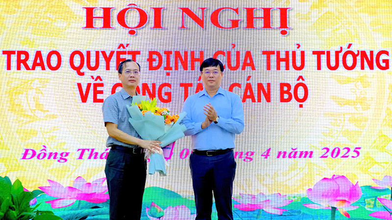 Ủy viên Trung ương Đảng, Bí thư Tỉnh ủy Đồng Tháp Lê Quốc Phong trao quyết định của Thủ tướng Chính phủ cho ông Trần Trí Quang và tặng hoa chúc mừng. (Ảnh: NHƯ ANH)