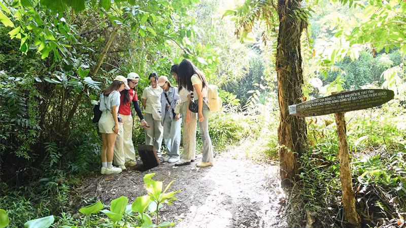 Du khách trẻ tham quan hầm bí mật tại Khu di tích Xẻo Quít. (Ảnh: HỮU NGHĨA)