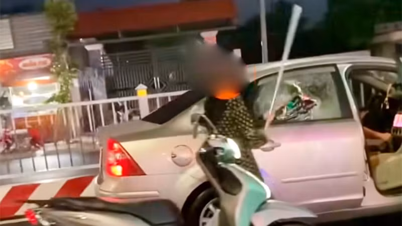 Bà T.T.B.L dùng 1 thanh kim loại đập vỡ kính và chèn ép 1 xe ô-tô đang chạy. (Ảnh: Công an cung cấp)