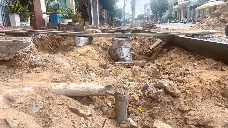 Những thanh ván được lắp đặt tạm làm phương tiện lên xuống từ cửa nhà dân ra đường lộ trông mất an toàn. (Ảnh: HỮU NGHĨA)