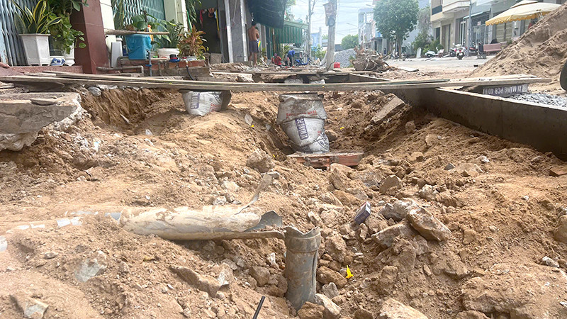 Những thanh ván được lắp đặt tạm làm phương tiện lên xuống từ cửa nhà dân ra đường lộ trông mất an toàn. (Ảnh: HỮU NGHĨA)