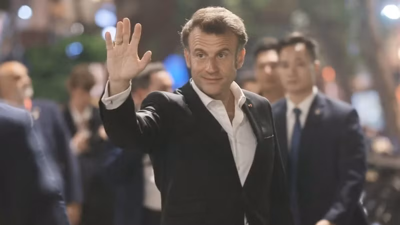 Tổng thống Pháp Emmanuel Macron vẫy chào người dân Thủ đô. (Ảnh: TTXVN)