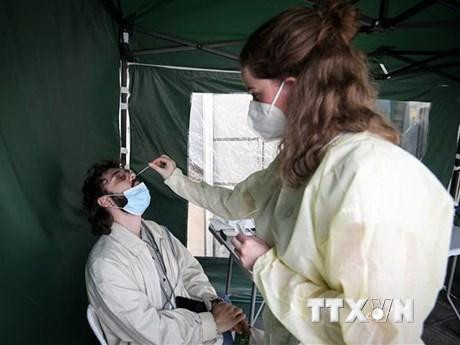 Nhân viên y tế lấy mẫu xét nghiệm Covid-19 cho người dân tại Paris, Pháp. (Ảnh: AFP/TTXVN)