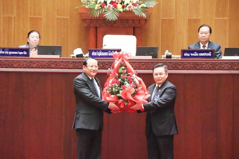 Chủ tịch Quốc hội Lào Saysomphone Phomvihane tặng hoa chúc mừng tân Thủ tướng Sonexay Siphandone. (Ảnh: Báo Pasaxon)