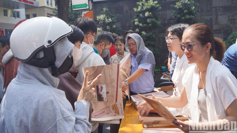 Lãnh đạo, phóng viên Cơ quan đại diện Báo Nhân Dân tại khu vực miền nam trao phụ san đặc biệt cho bạn đọc.