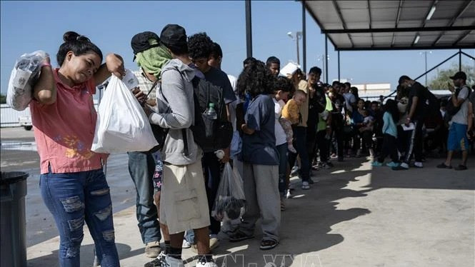 Người di cư chờ lên xe buýt để được trung chuyển khỏi bang Texas, Mỹ. (Ảnh minh họa: AFP/TTXVN)