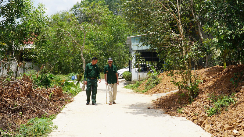 Hai cha con ông Bùi Văn Tượng đi trên con đường mới từ một phần đất gia đình đóng góp.