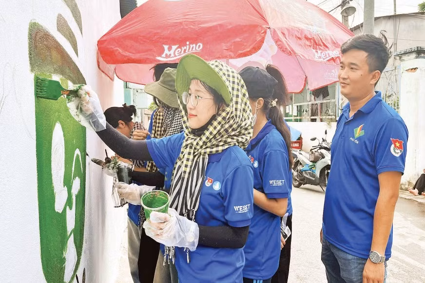 Sinh viên tình nguyện Trường đại học Giao thông vận tải Phân hiệu Thành phố Hồ Chí Minh vẽ tranh cổ động tại hẻm 74 đường làng Tăng Phú (phường Tăng Nhơn Phú).