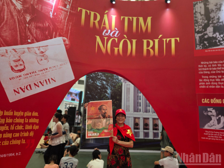 Bác gái tự hào chụp cùng tờ phụ san có in hình Chủ tịch Hồ Chí Minh. ndo_br_1000098212.jpg