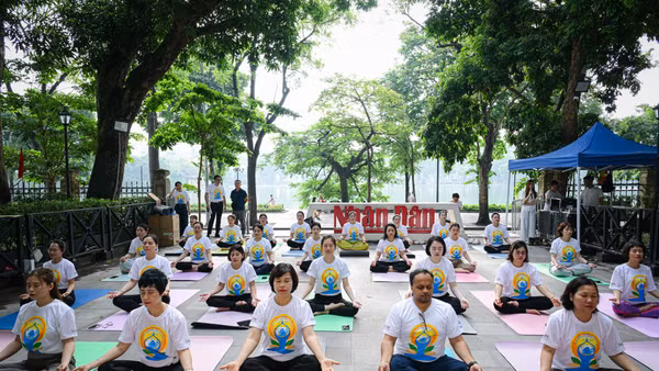 Các đại biểu, cùng đông đảo phóng viên, biên tập viên, người lao động Báo Nhân Dân tham gia màn đồng diễn Yoga tại khuôn viên trụ sở Báo Nhân Dân tại Hà Nội. (Ảnh: BẢO LONG)