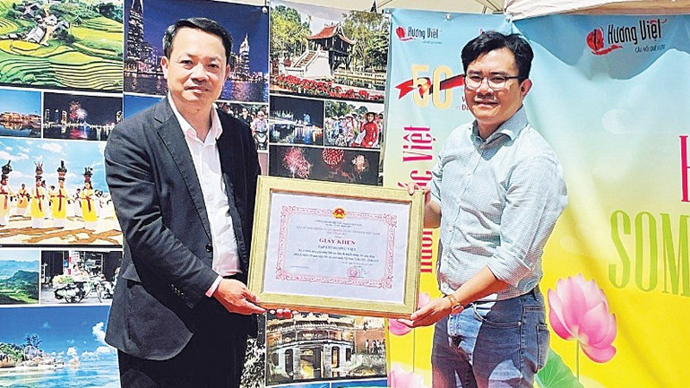 Anh Phạm Khánh Nam (bên phải) và tạp chí Hương Việt tổ chức chương trình “Hương Sắc Việt” quảng bá văn hóa Việt Nam tại Đức nhân kỷ niệm 50 năm quan hệ ngoại giao Việt Nam - Đức, nhận Giấy khen của Đại sứ quán Việt Nam tại Đức. (Ảnh: Nhân vật cung cấp) tu-nhung-chuyen-di-doi-doi-1-5289.jpg