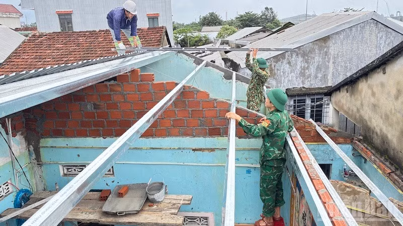 Cán bộ và chiến sĩ Đồn Biên phòng cửa khẩu cảng Dung Quất sửa chữa, xây dựng nhà cho người dân ven biển.