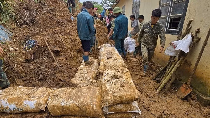 Cán bộ, chiến sĩ Ban Chỉ huy Bộ đội Biên phòng tỉnh Điện Biên cùng người dân dọn nhà cửa, khắc phục hậu quả do lũ quét. (Ảnh: LÊ LAN)
