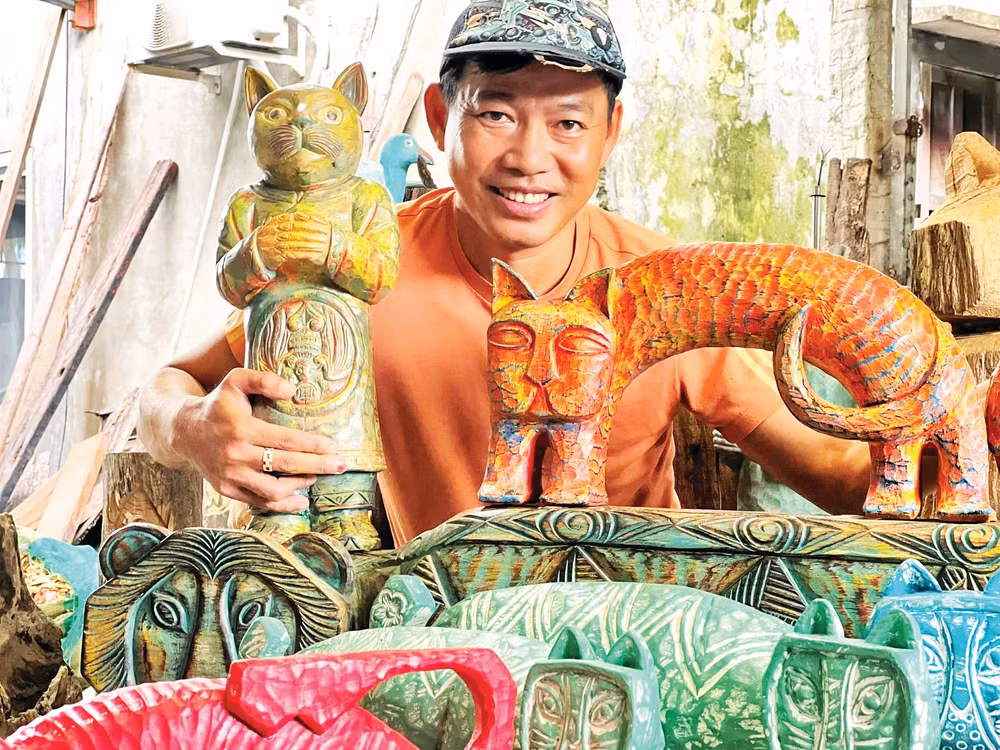 Anh Lê Ngọc Thuận bên một số tác phẩm từ củi lũ. (Ảnh: NVCC)