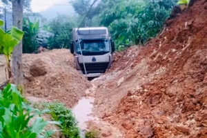 Xe đầu kéo bị đất đá vùi lấp tại đường tỉnh 164. (Ảnh: THANH SƠN)