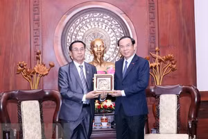 Bí thư Thành ủy Thành phố Hồ Chí Minh Nguyễn Văn Nên trao tặng phẩm lưu niệm cho ông Khampheng Vilaphanh. (Ảnh: TTXVN)