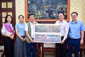 Đồng chí Phạm Song Hà, Ủy viên Ban Biên tập, Trưởng Ban Chính trị - Xã hội tặng phụ san cho trưởng nhóm tác giả.