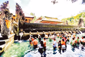 Người dân và du khách xếp hàng chờ đến lượt thực hiện nghi thức tắm nước suối thiêng ở đền Tirta Empul.