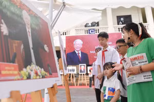 Giáo viên Trường trung học cơ sở Phúc Xá (quận Ba Đình, Hà Nội) giới thiệu cho học sinh từng bức ảnh tại triển lãm.