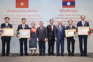 Chủ tịch Ủy ban Trung ương Mặt trận Lào xây dựng đất nước Sinlavong Khoutphaythoune và Chủ tịch Ủy ban Trung ương MTTQ Việt Nam Đỗ Văn Chiến chụp ảnh lưu niệm với các cá nhân được nhận Huân chương Ít-xa-la hạng II, III 