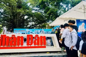 Đông đảo bạn trẻ xếp hàng để thăm quan triển lãm và nhận số báo đặc biệt về Chủ tịch Hồ Chí Minh. (Ảnh: HNV)