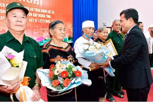 Bí thư Tỉnh ủy Hồ Văn Niên tặng hoa, bằng khen cho các đại biểu người có công và thân nhân liệt sĩ. (Ảnh: Đức Thụy)